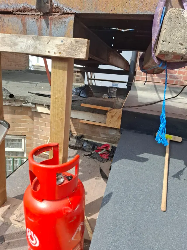 Felt roofing being torch-applied to the new decking